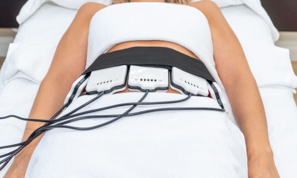 Woman receiving laser liposuction treatment with low-level laser devices on abdomen, promoting non-invasive fat reduction at Superior Sculpting in Vero Beach, FL.